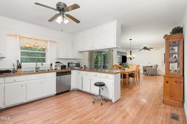 kitchen with stainless steel appliances, ceiling fan, a sink, light wood-type flooring, and a peninsula