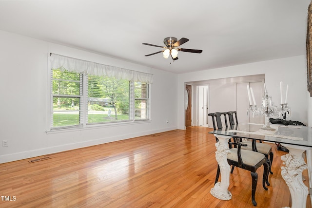 office space featuring baseboards, visible vents, a ceiling fan, and light wood finished floors