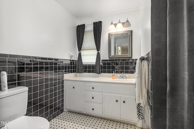 bathroom featuring wainscoting, tile walls, ornamental molding, toilet, and vanity