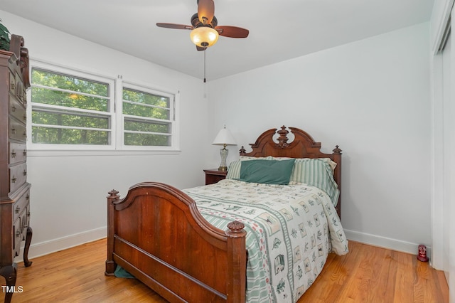 bedroom with baseboards, wood finished floors, and ceiling fan