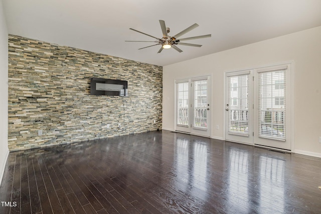 unfurnished living room featuring ceiling fan, dark wood-style flooring, and baseboards