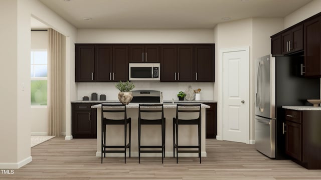 kitchen featuring tasteful backsplash, stainless steel appliances, a breakfast bar area, and a kitchen island