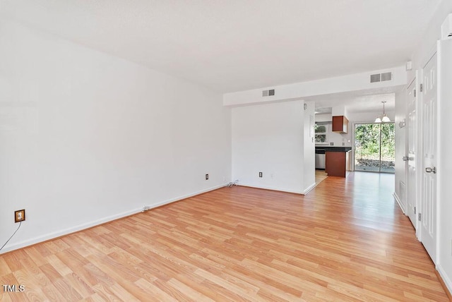 spare room featuring visible vents, light wood-style flooring, and baseboards