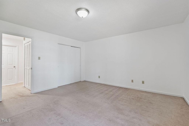 unfurnished bedroom with light carpet, a closet, and baseboards