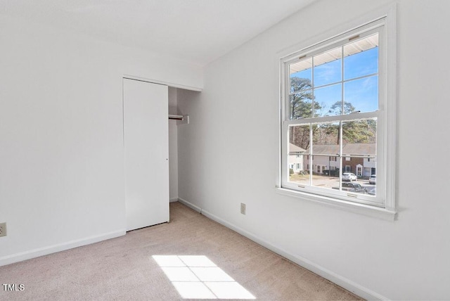 unfurnished bedroom featuring a closet, baseboards, and carpet flooring