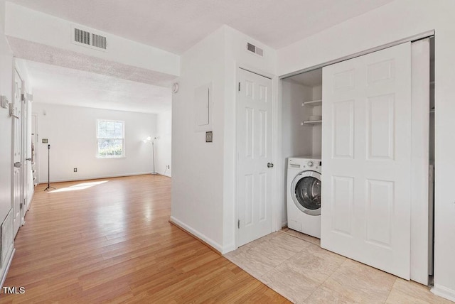 laundry area with washer / dryer, laundry area, visible vents, and light wood finished floors