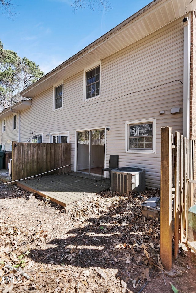 back of house with a deck, cooling unit, and fence