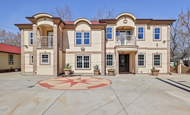 mediterranean / spanish-style house with a balcony and stucco siding