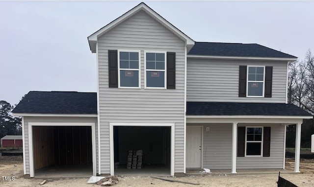 view of property featuring a garage and covered porch