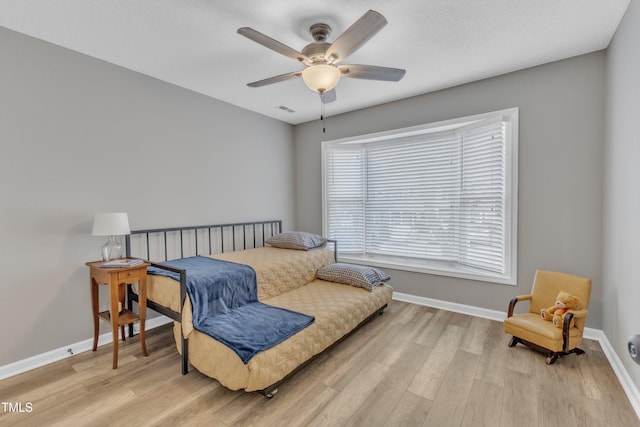 bedroom featuring light wood-style flooring, visible vents, and baseboards