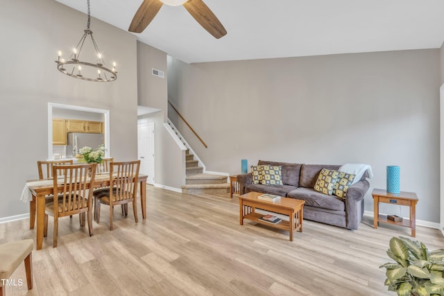 living area featuring light wood-style floors, stairs, and visible vents