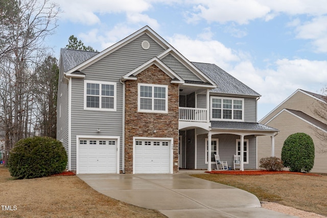 view of front facade with a garage, a front yard, a balcony, and a porch