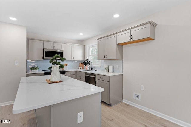 kitchen featuring gray cabinetry, sink, tasteful backsplash, and appliances with stainless steel finishes