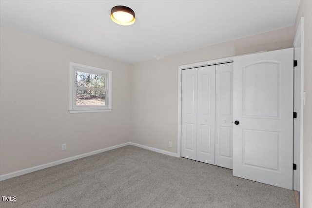 unfurnished bedroom featuring light colored carpet and a closet