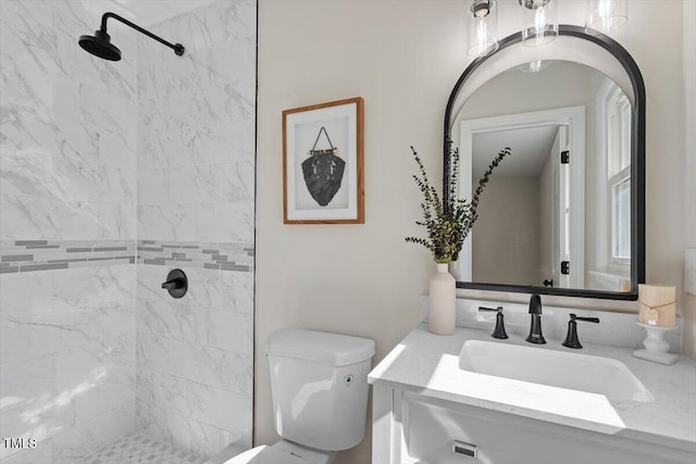 bathroom featuring vanity, toilet, and tiled shower