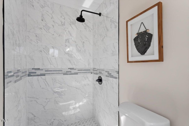 bathroom featuring tiled shower and toilet