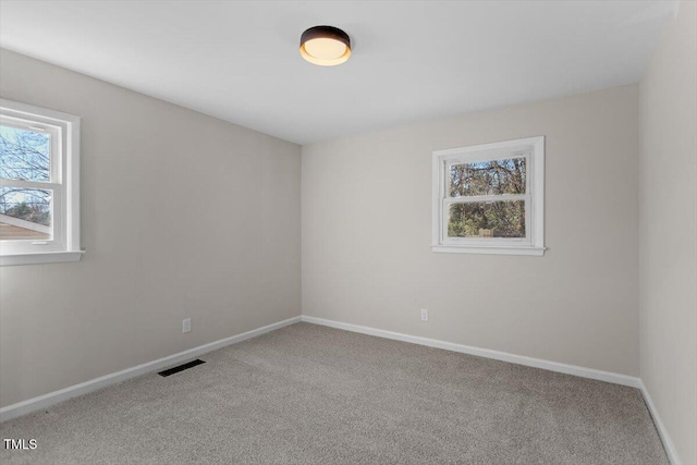 spare room featuring a healthy amount of sunlight and carpet flooring