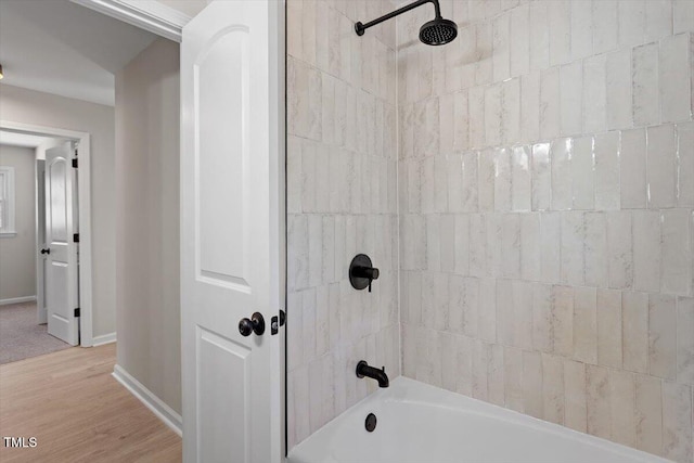 bathroom with tiled shower / bath and wood-type flooring