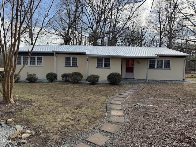 ranch-style home with metal roof and concrete block siding