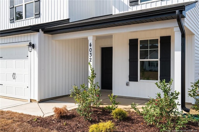 view of exterior entry featuring a garage and a porch