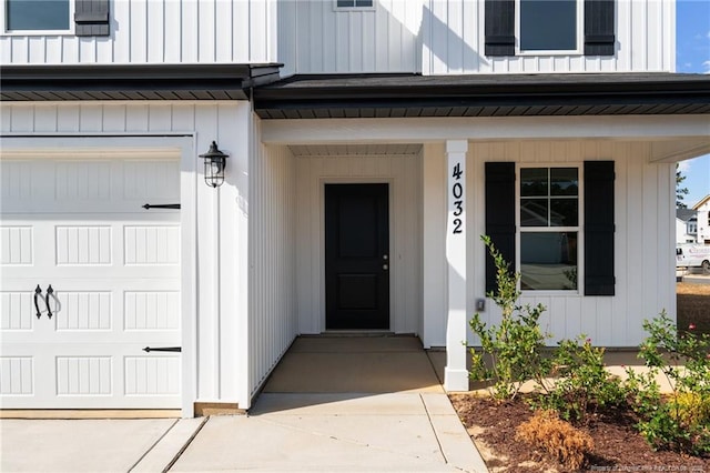 entrance to property with board and batten siding and an attached garage