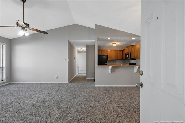 unfurnished living room with vaulted ceiling, carpet, and ceiling fan