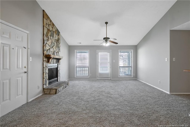 unfurnished living room with a stone fireplace, carpet floors, high vaulted ceiling, and ceiling fan