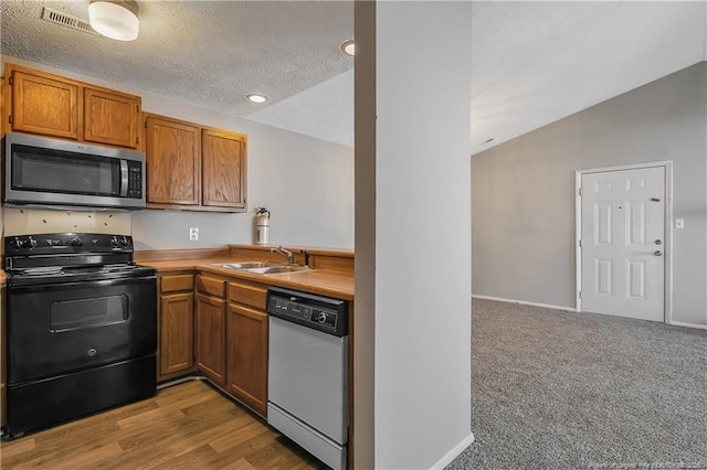 kitchen with lofted ceiling, black electric range oven, sink, dishwashing machine, and a textured ceiling