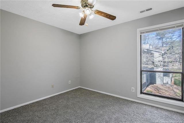 carpeted empty room with ceiling fan and a textured ceiling