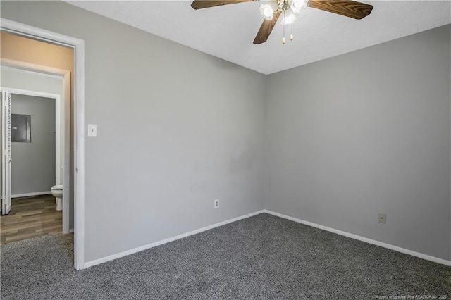 spare room with ceiling fan and dark colored carpet