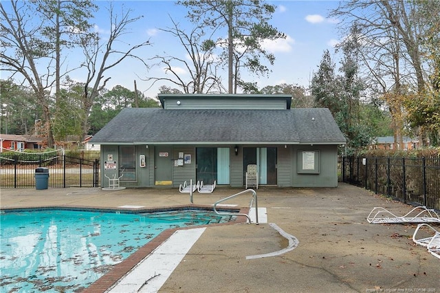 back of property with a community pool and a patio area