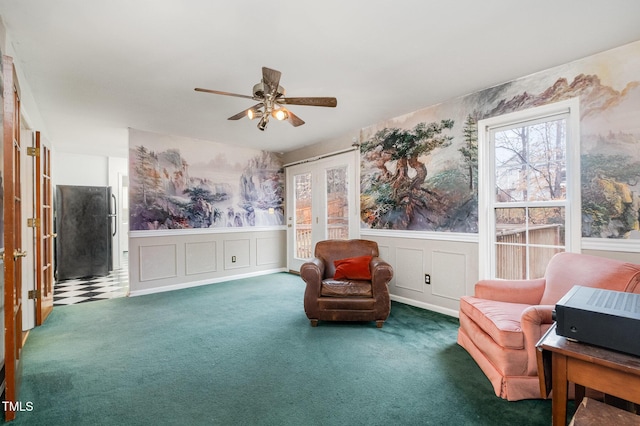 sitting room featuring dark carpet and ceiling fan