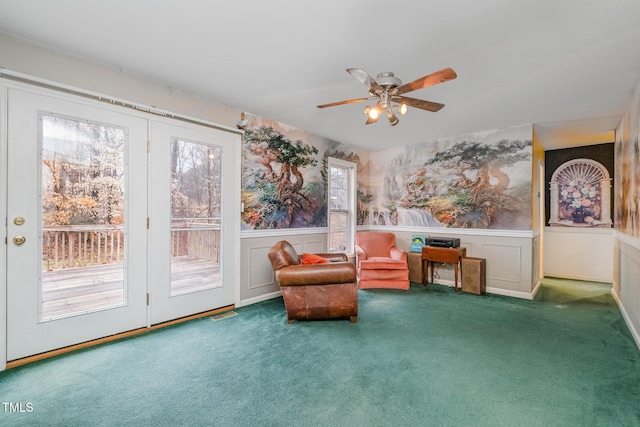 sitting room featuring dark carpet and ceiling fan