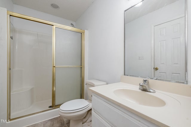 bathroom featuring tile patterned flooring, toilet, vanity, and walk in shower