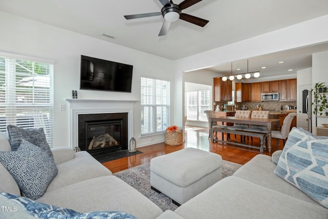 living room with ceiling fan and light wood-type flooring