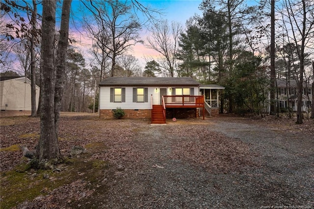 view of front facade with a wooden deck and a sunroom