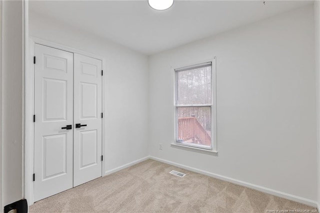 empty room featuring plenty of natural light and light colored carpet