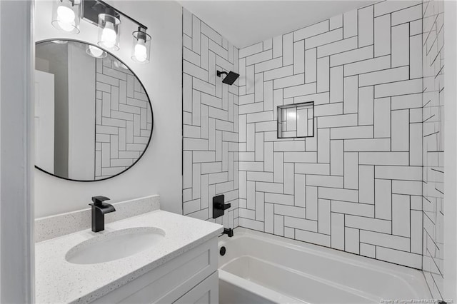 bathroom featuring tiled shower / bath and vanity