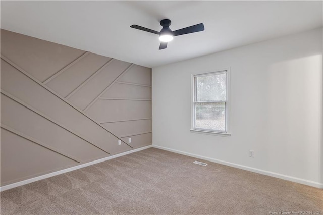 carpeted spare room featuring ceiling fan