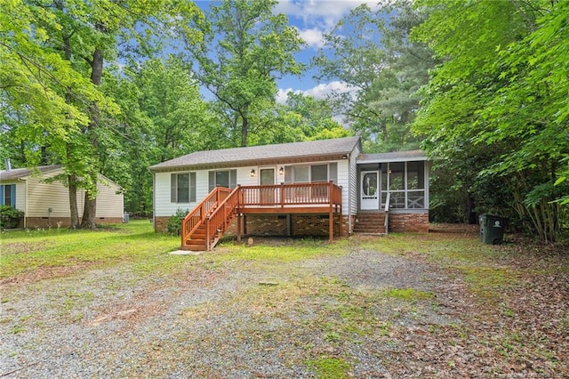 5802 Lillie Dr, Durham, NC 27712 - view of front facade with a sunroom, stairs, crawl space, and a wooden deck