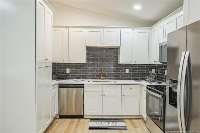 5802 Lillie Dr, Durham, NC 27712 - kitchen featuring stainless steel appliances, a sink, light countertops, lofted ceiling, and tasteful backsplash
