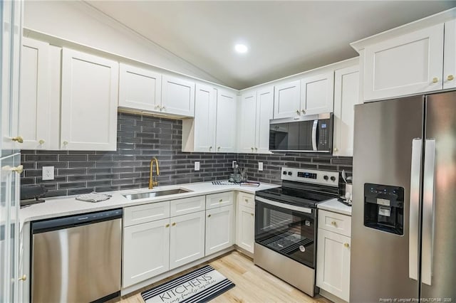 5802 Lillie Dr, Durham, NC 27712 - kitchen with appliances with stainless steel finishes, a sink, light countertops, lofted ceiling, and decorative backsplash