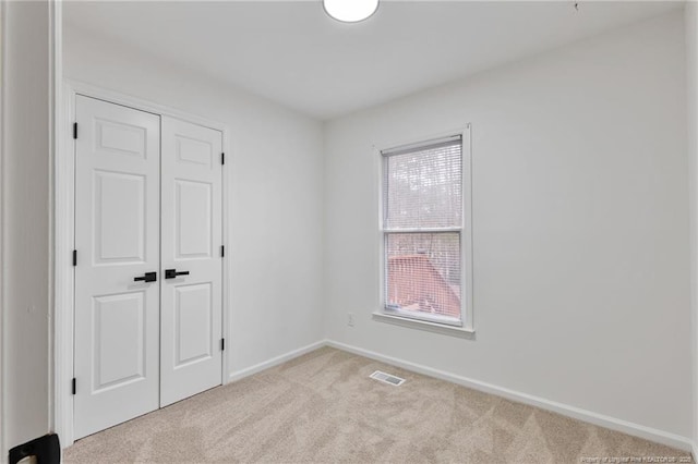 5802 Lillie Dr, Durham, NC 27712 - unfurnished bedroom featuring light colored carpet, baseboards, and a closet