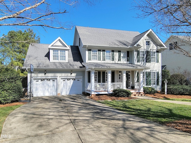 view of front facade featuring a front yard, covered porch, an attached garage, and concrete driveway