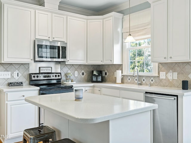 kitchen with stainless steel appliances, a breakfast bar, a sink, and white cabinets