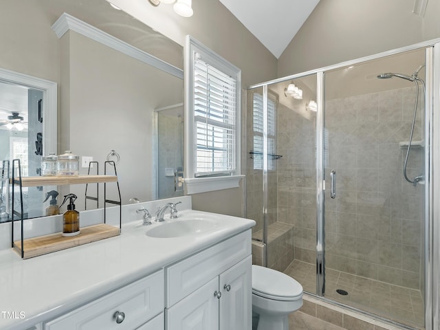 bathroom featuring toilet, a ceiling fan, a stall shower, vaulted ceiling, and vanity