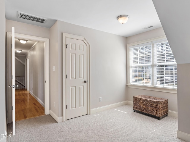 unfurnished bedroom featuring carpet flooring, visible vents, and baseboards