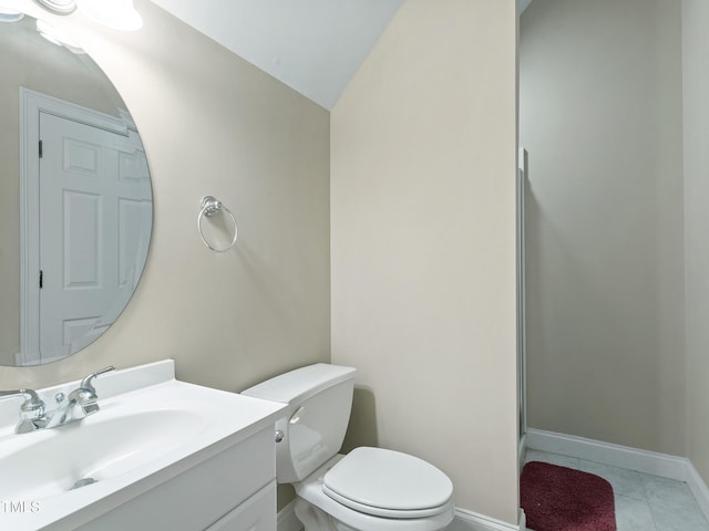 bathroom featuring toilet, tile patterned floors, baseboards, and vanity