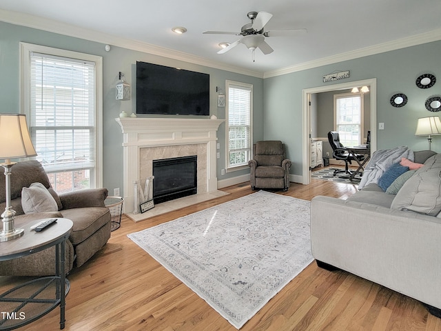 living area with crown molding and light wood-style flooring