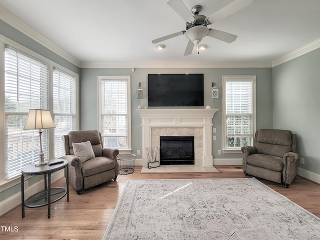 living area with ornamental molding, plenty of natural light, and wood finished floors